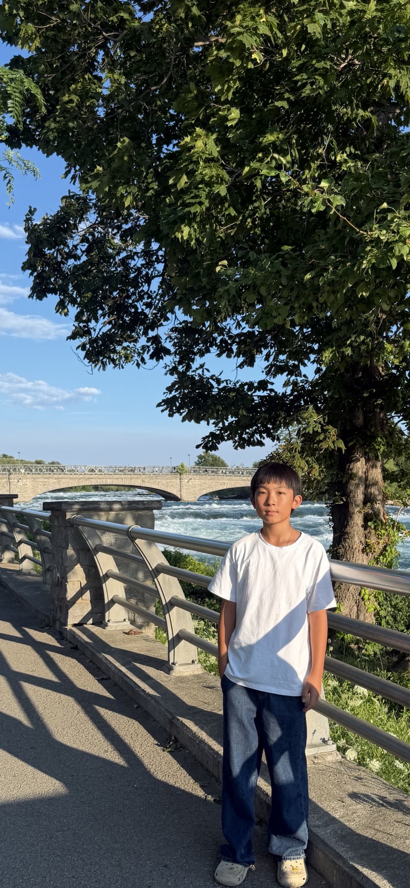 Jayden Chen standing beside the river on a sunny day